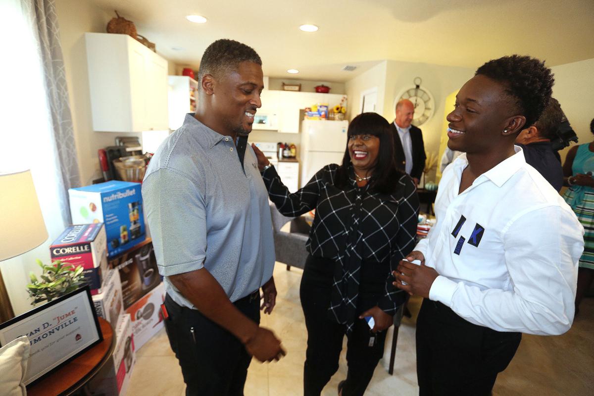 Former NFL running back Warrick Dunn spends time with new homeowners LaToya Reedy and her son, AnTrez Reedy, in St. Petersburg, Fla., on October 15, 2019. A single mother, Reedy is buying her first home through the Habitat Pinellas and West Pasco homeownership program.