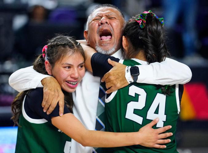 Tuba City head coach Peterson Butler hugs Nakota Tallman (5) and Layla Curtis (24) after winning the Copper Division Championship game over Snowflake at Arizona Veterans Memorial Coliseum in Phoenix on Feb. 28, 2026.