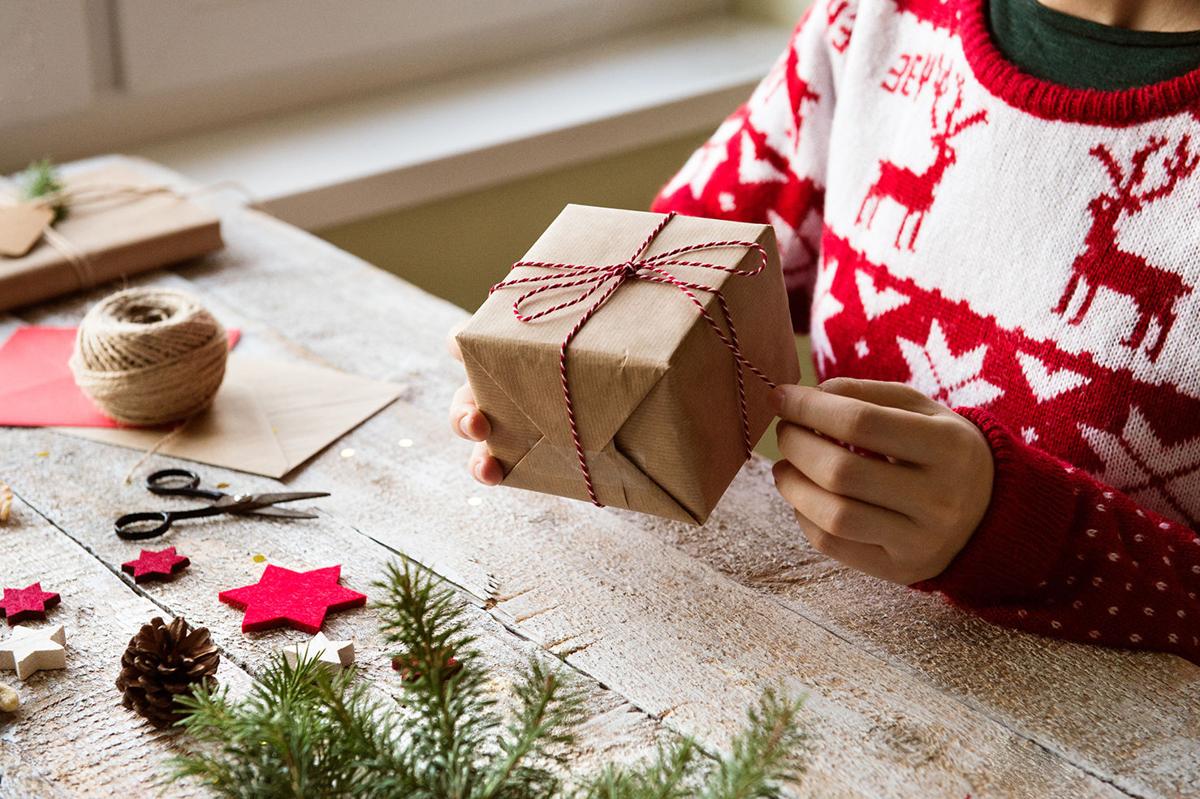 Unrecognizable woman wrapping and decorating Christmas present