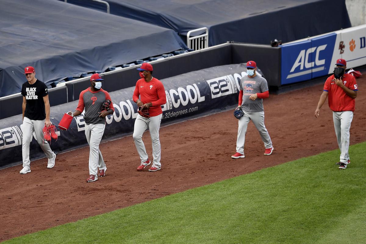 Philadelphia Phillies players walk toward the dugout after batting practice prior to the start of a game against the New York Yankees at Yankee Stadium on Monday, August 3, 2020 in the Bronx borough of New York City. The Phillies were playing for the first time in eight days after several team members tested positive for COVID-19 last week.