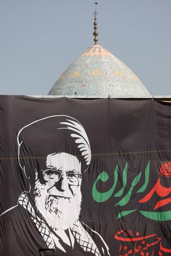A banner with a picture of the late Supreme Leader of Iran, Ayatollah Ali Khamenei, next to the dome of a mosque in Tehran