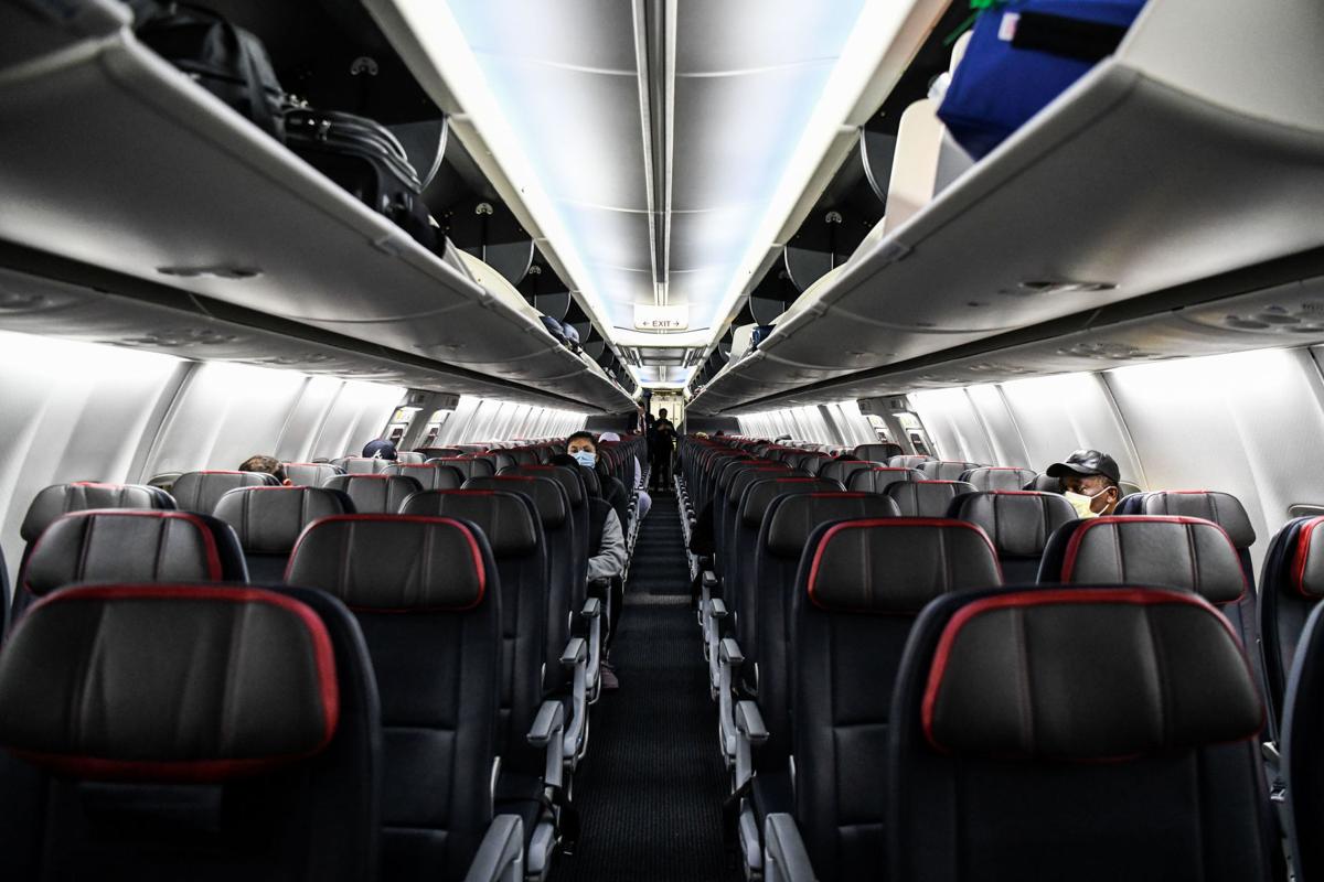 Passengers sit at a distance inside a flight from Miami to Atlanta on April 23, 2020.
