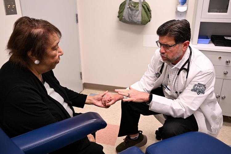 Dr. Mirza Beg, division head of geriatrics at Henry Ford Health, talks with Althea Anderson, 84, about medications and other topics near the end of their appointment at Henry Ford Medical Center - Livonia in October. Providers like Beg are in high demand a