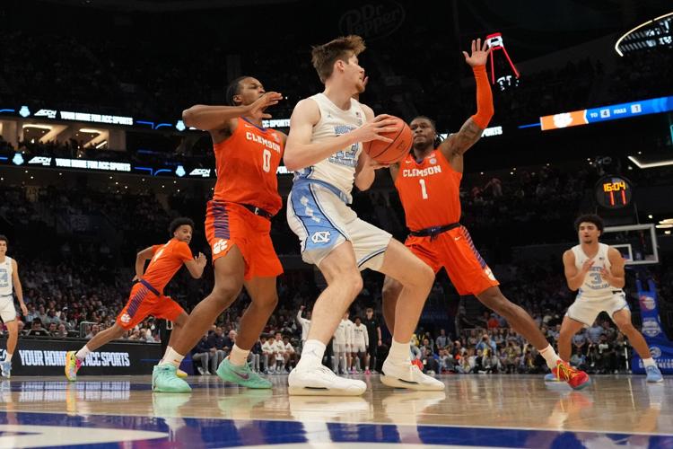 Mar 12, 2026; Charlotte, NC, USA; North Carolina Tar Heels center Henri Veesaar (13) is pressured by Clemson Tigers forward RJ Godfrey (0) and guard Jestin Porter (1) during the first half at Spectrum Center. Mandatory Credit: Jim Dedmon-Imagn Images