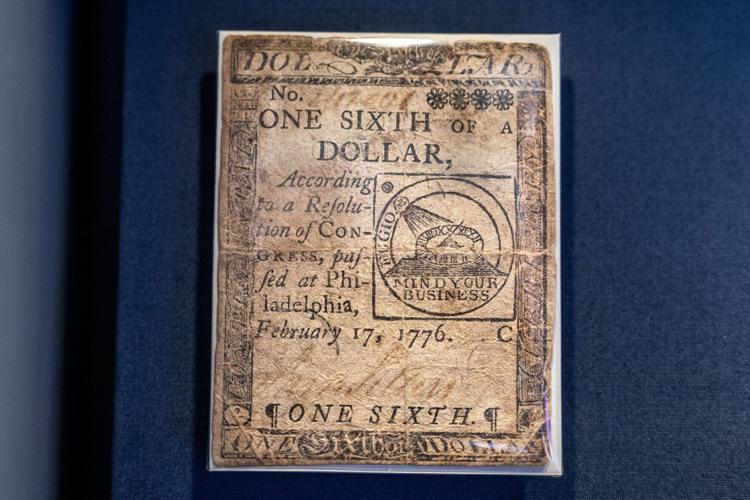 A Continental one-sixth dollar bill on display at the Federal Reserve Bank of Philadelphia’ s newly redesigned“ Money in Motion” exhibit Thursday, May 7, 2026. This bill was issued in Philadelphia by the Continental Congress on Feb. 17, 1776, to fund the Revolutionary War. Designed by Benjamin Franklin, the note features a“ Fugio "motif and the phrase" Mind Your...