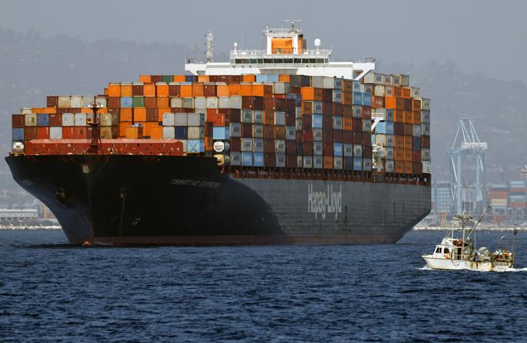A fishing boat passes a container ship floating off the Port of Los Angeles on July 17, 2026 in Los Angeles, California.