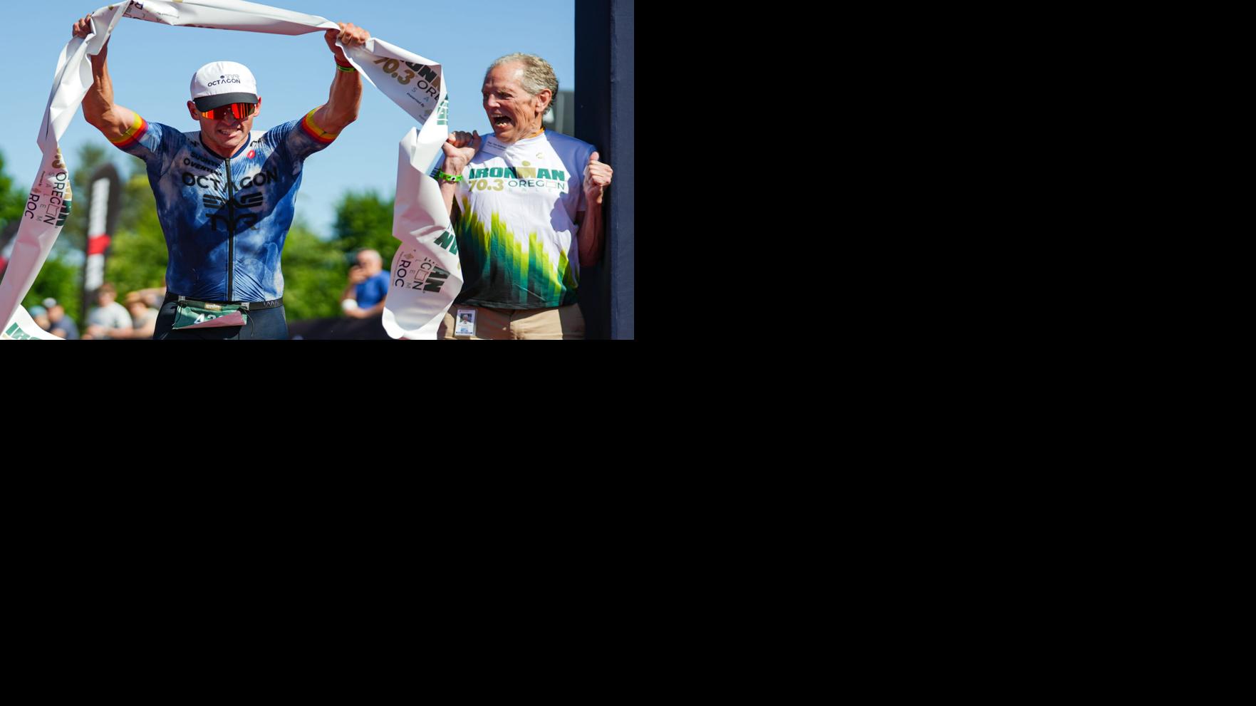 Soren Jensen, of Tucson, Arizona, left, crosses the finish line to win the Ironman 70.3 Oregon men's division in 3 hours, 50 minutes, 12 seconds as Rep. Tom Andersen, D-Salem, celebrates.