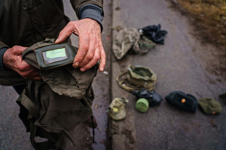A Ukrainian soldier displays military items collected from Russian forces in Sytnyaky, Ukraine, Thursday, March 3, 2022.