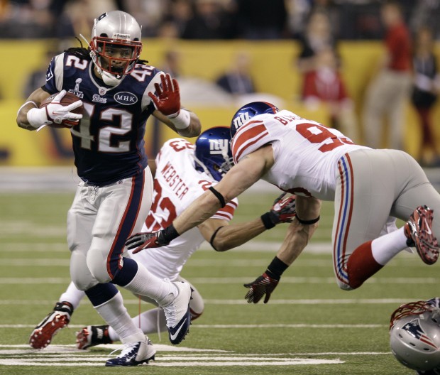 Tight end Aaron Hernandez (81) of the New England Patriots avoids the  tackle of strong safety Deon Grant (34) of the New York Giants to score on  the opening drive of the