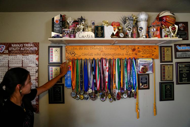 Layla Curtis shows off her medals inside her home on The Gap on the Navajo reservation near Tuba City, Arizona, on Aug. 12, 2026.