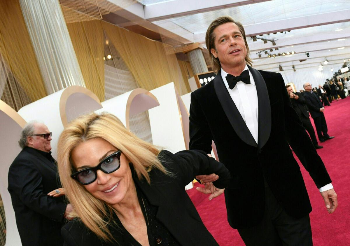 Actor Brad Pitt is pulled along by a publicist as he arrives for the 92nd Oscars at the Dolby Theatre in Hollywood, California, on Feb. 9, 2020.