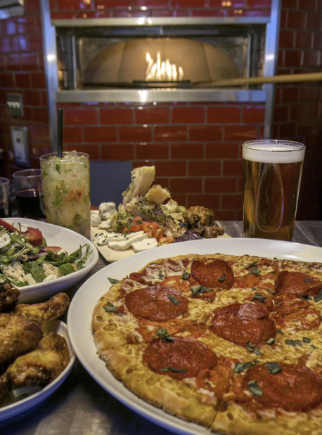 Aaron May flipping pizzas