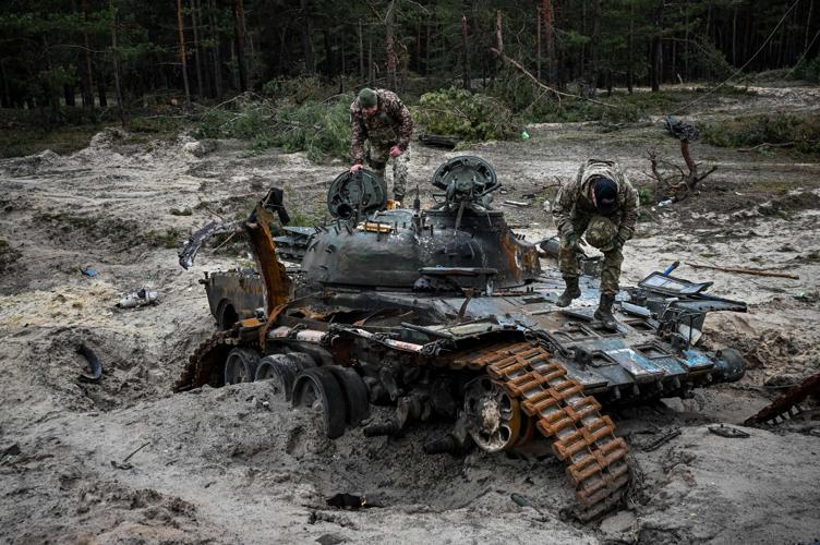 Ukrainian servicemen inspect a destroyed Russian tank near Kivsharivka village in a suburb of Kupiansk, Kharkiv region on Dec. 15, 2022, amid the Russian invasion of Ukraine.
