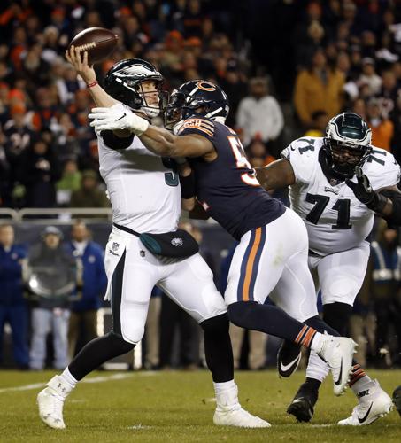 Philadelphia Eagles quarterback Nick Foles (9) gets a pass off as he's hit by Chicago Bears outside linebacker Khalil Mack (52) in the fourth quarter during the NFC Wild Card game on Sunday, Jan. 6, 2019 at Soldier Field in Chicago, Ill. The Eagles beat the Bears, 16-15.