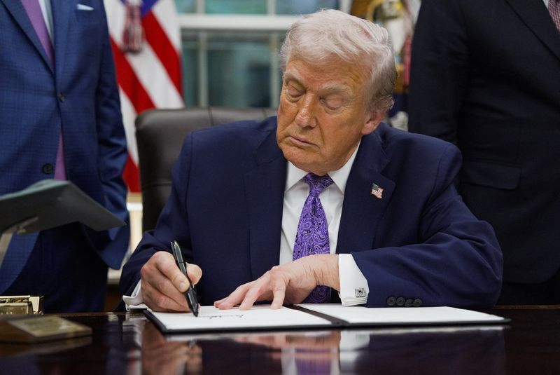 U.S. President Donald Trump signs an executive order in the Oval Office of the White House
