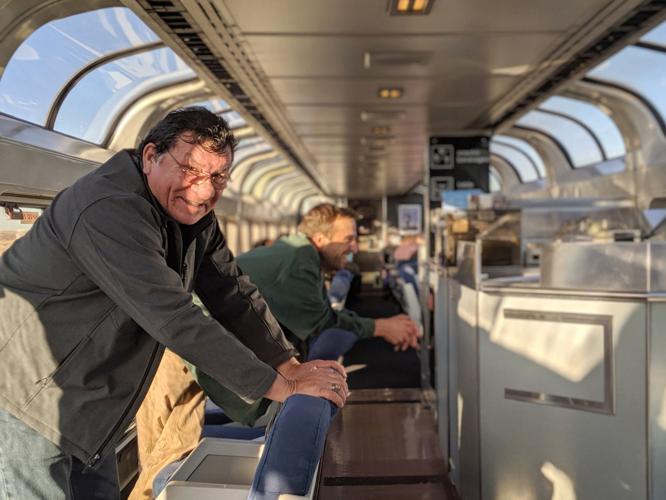 Teddy Christjohn, 71, of Wisconsin and James Lotterer, 31, of New York, who met in the train's observation car, look out the window at the John Martin Reservoir in Colorado.