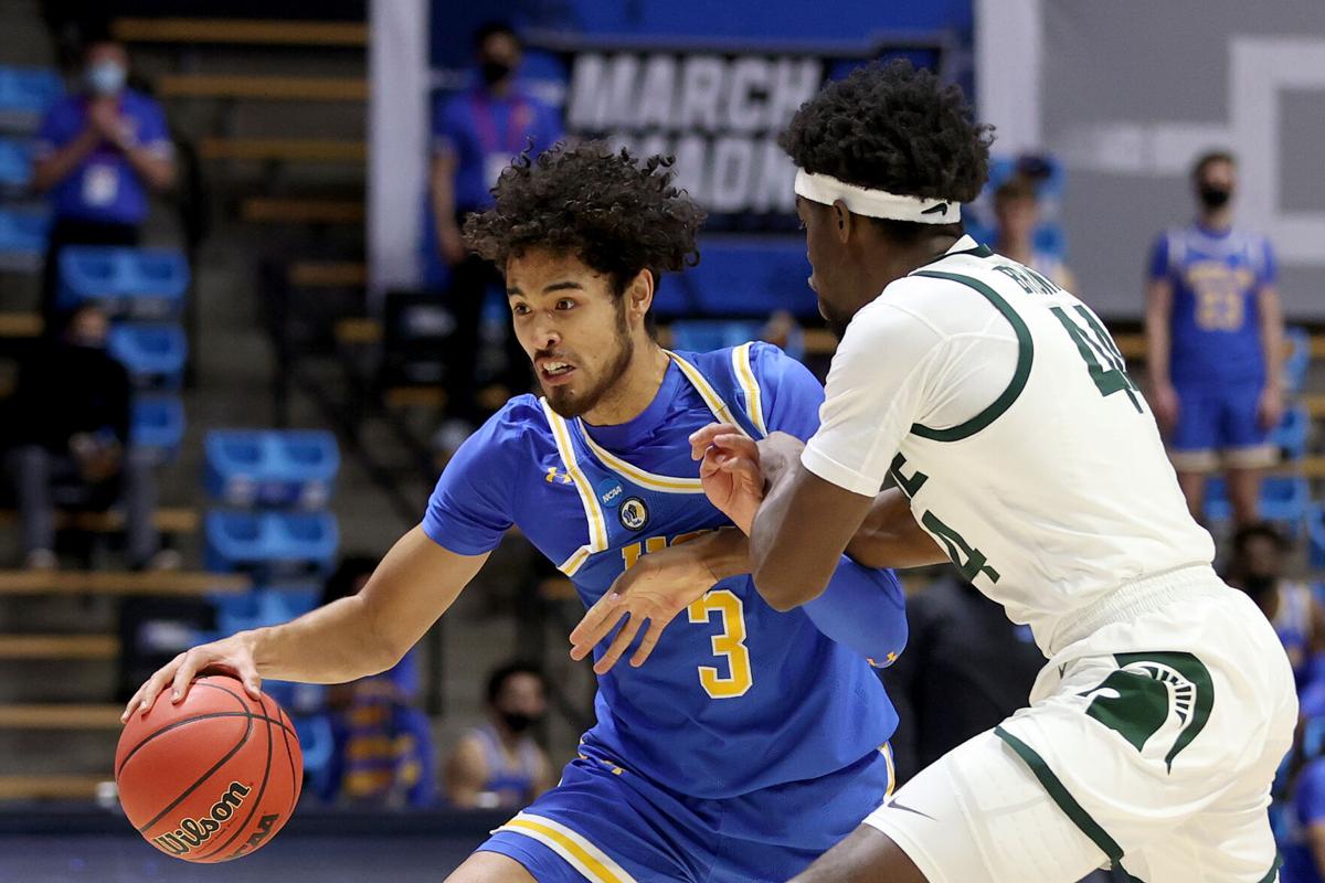 UCLA's Johnny Juzang drives against Michigan State's Gabe Brown during the first half in the NCAA Tournament First Four game at Mackey Arena in West Lafayette, Indiana, on Thursday, March 18, 2021.