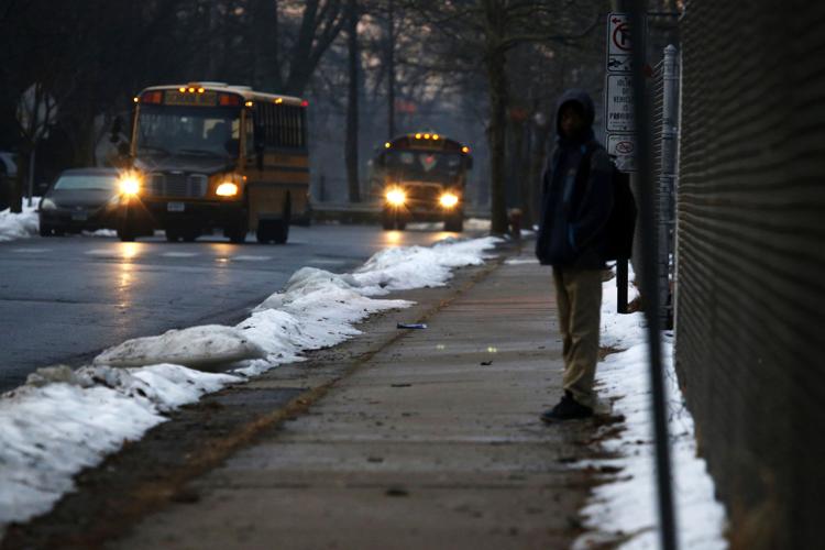 Waiting for a bus outside John C. Clark Elementary and Middle School