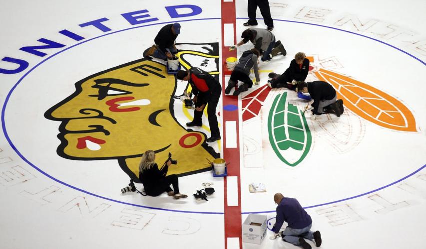 United Center workers bring the Blackhawks logo back to life at center ice.