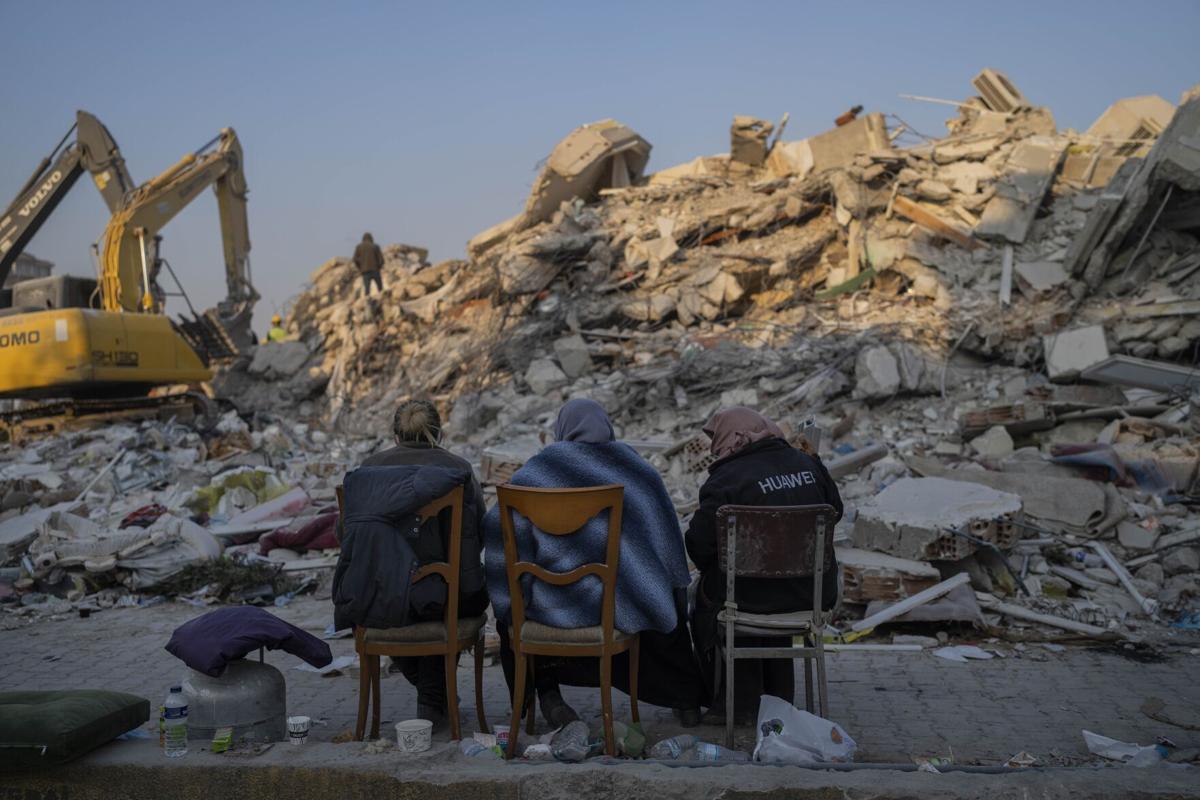 Quake survivors wait amid rubble, to search or say goodbye
