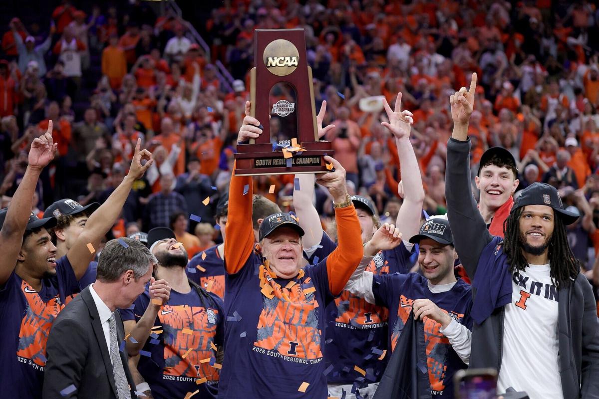 Illinois head coach Brad Underwood hoists the trophy with his team after defeating Iowa, 71-59, in the Elite Eight round of the NCAA Tournament at Toyota Center on Saturday, March 28, 2026, in Houston.