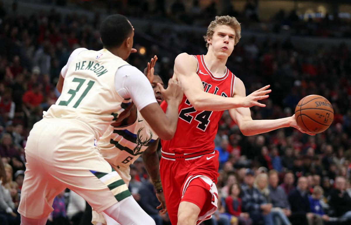 Chicago Bulls forward Lauri Markkanen (24) passes around Milwaukee Bucks forward John Henson (31) in the first half on Sunday, Jan. 28, 2018 at the United Center in Chicago.