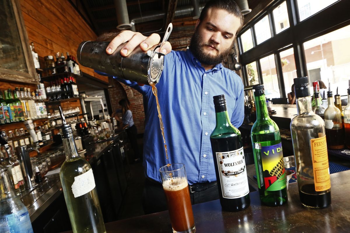 Darksome guys sharing the bartender at a pub
