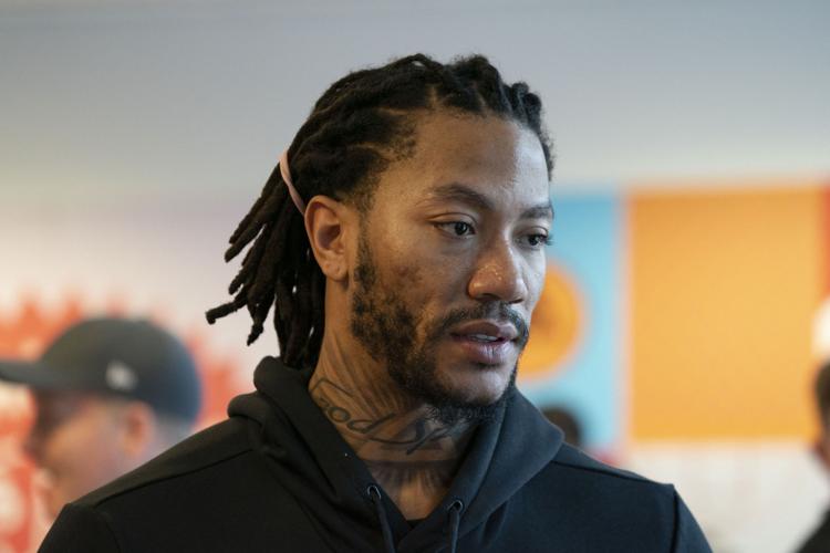 Derrick Rose works with students in a shoe design workshop.
