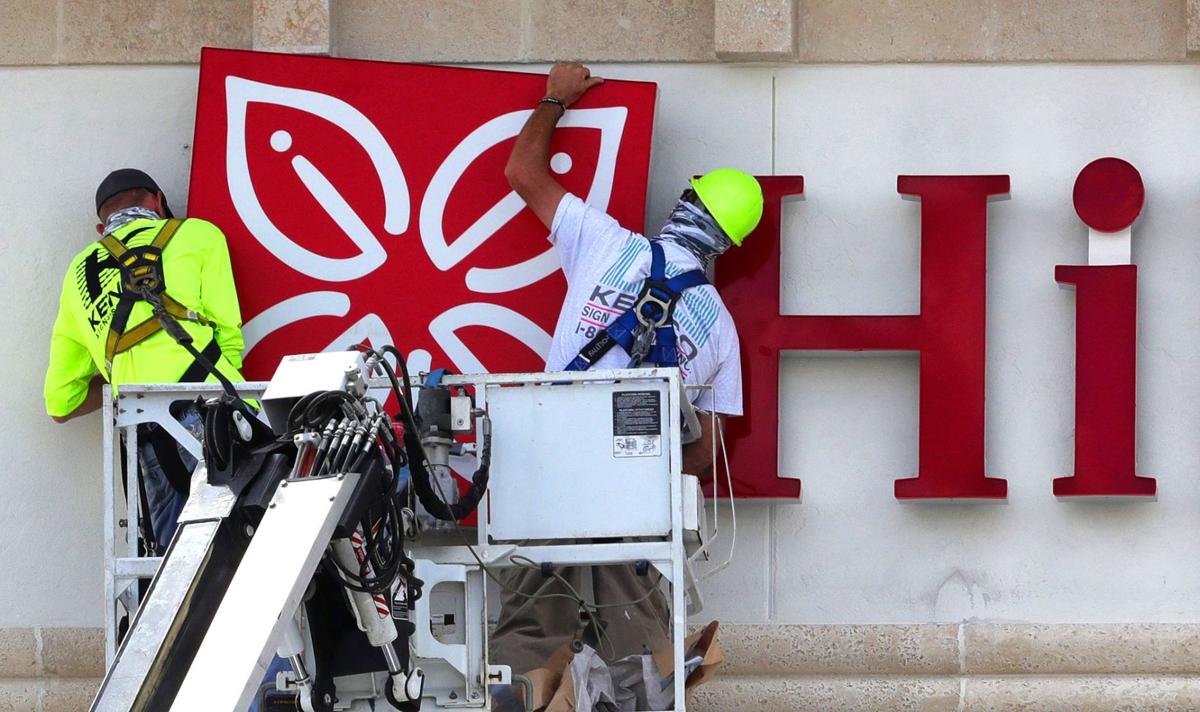 Workers installing signage for a new Hilton Garden Inn in Winter Park, Fla., appear to get a humorous greeting during the work on April 6, 2020.