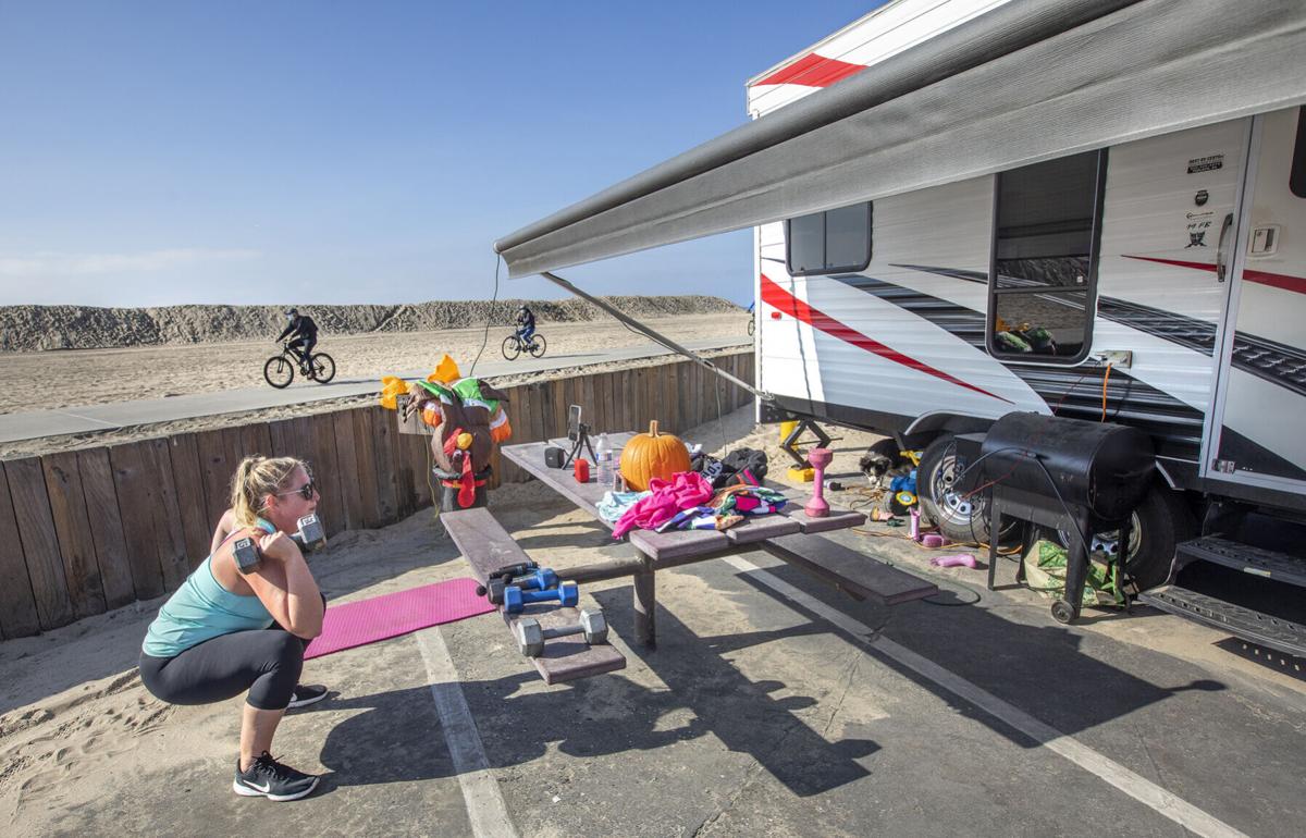 Leah Llere does a high intensity interval training workout outside her RV camper at Dockweiler Rv Park in Playa del Rey, California on Nov. 25, 2020.