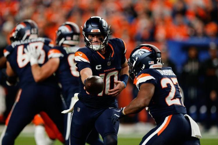Week 4: Denver Broncos quarterback Bo Nix (10) hands the ball off to running back J.K. Dobbins during the "Monday Night Football" ga,e against the Cincinnati Bengals at Empower Field at Mile High. The Broncos wore their "Midnight Navy" uniforms for the game.