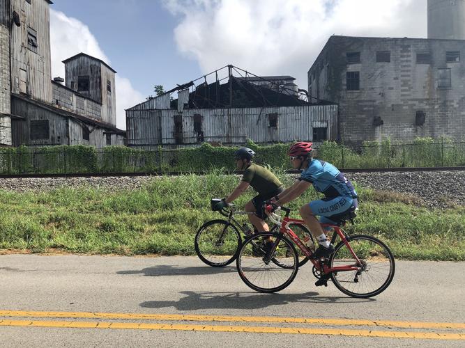 Cyclists can explore distilleries, farm country and whiskey-making towns on a two-wheeled tour of Kentucky's bourbon country. The writer's friends, Greg Dyas, left, and John Wheeler, ride past a dilapidated farm facility outside of Bardstown, Ky.