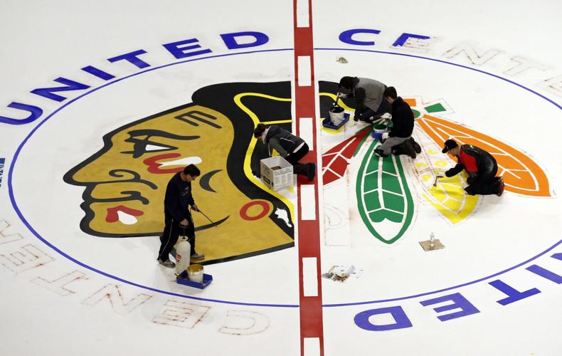 The Blackhawks logo is applied to the ice at the United Center.