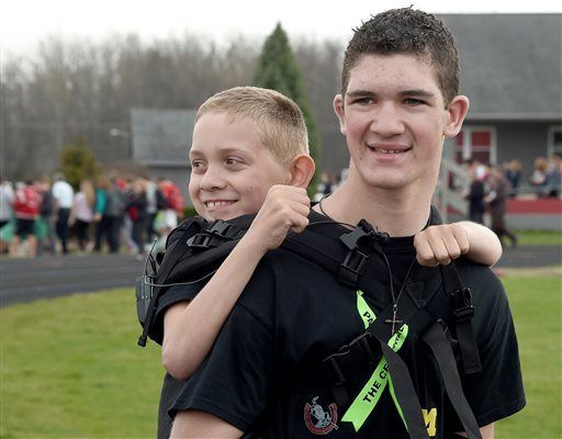 Michigan teen begins 111-mile walk with brother on back