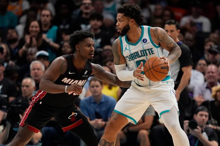Apr 14, 2026; Charlotte, North Carolina, USA; Charlotte Hornets forward Miles Bridges (0) looks to pass guarded by Miami Heat guard Davion Mitchell (45) during the second quarter during the play-in rounds between the Charlotte Hornets and the Miami Heat of