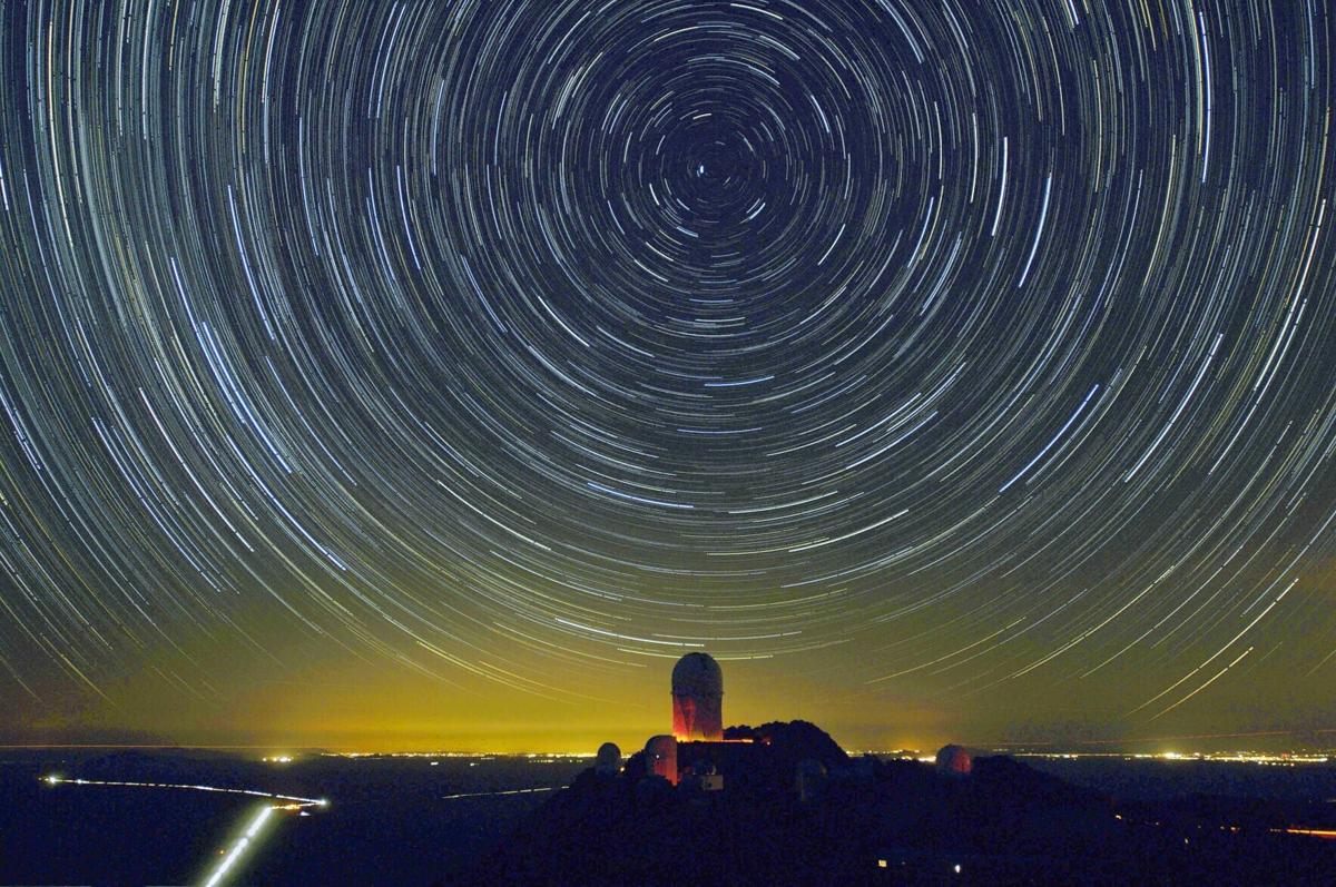 Stars appear to rotate around Polaris, the north star, in this time exposure, Jan. 26, 2006, above a view of the 4- meter telescope dome at Kitt Peak National Observatory near Tucson, Arizona. The image is composed of 114 30- second exposures of the night sky combined to make the equivalent of a nearly one hour exposure in which the earth's rotation causes the stars to...
