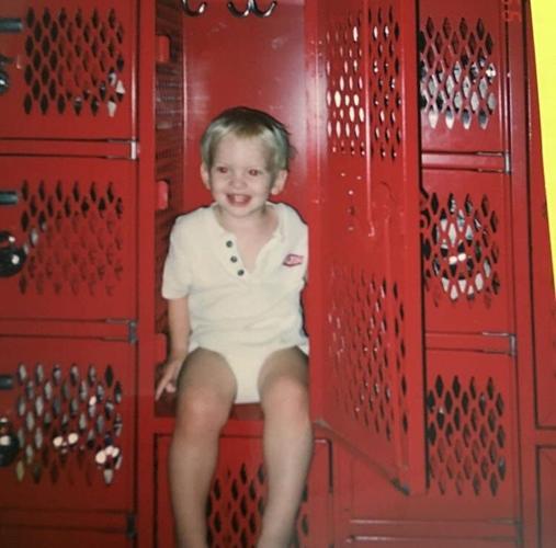 Grant House waits for his mother, Sue House, to finish preparing her team for a meet in 1999. She would stick him in a locker to keep him out of the way while she talked to her swimmers.