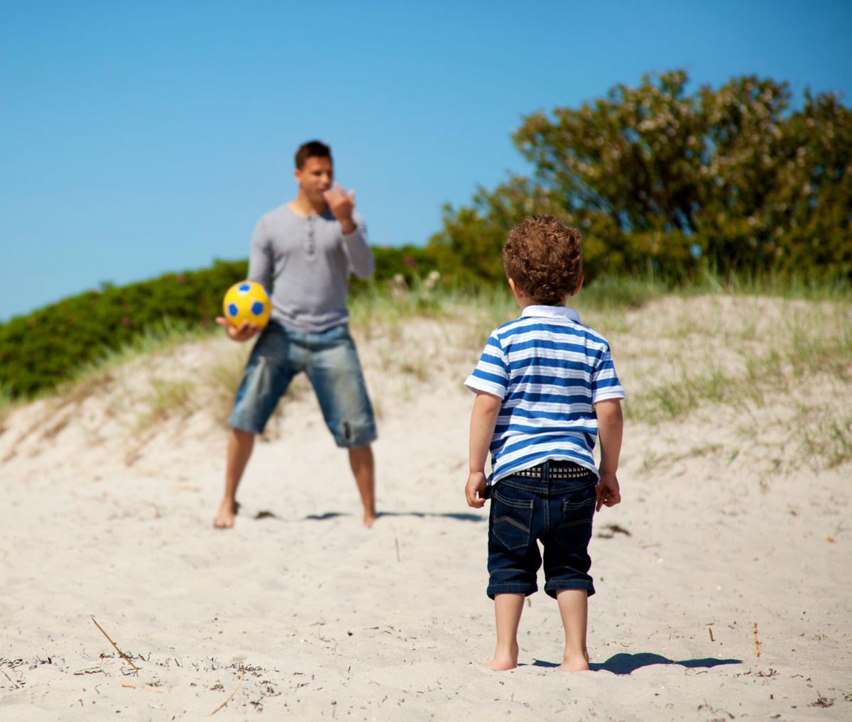 Child Looking at His Dad Teaching Him Soccer
