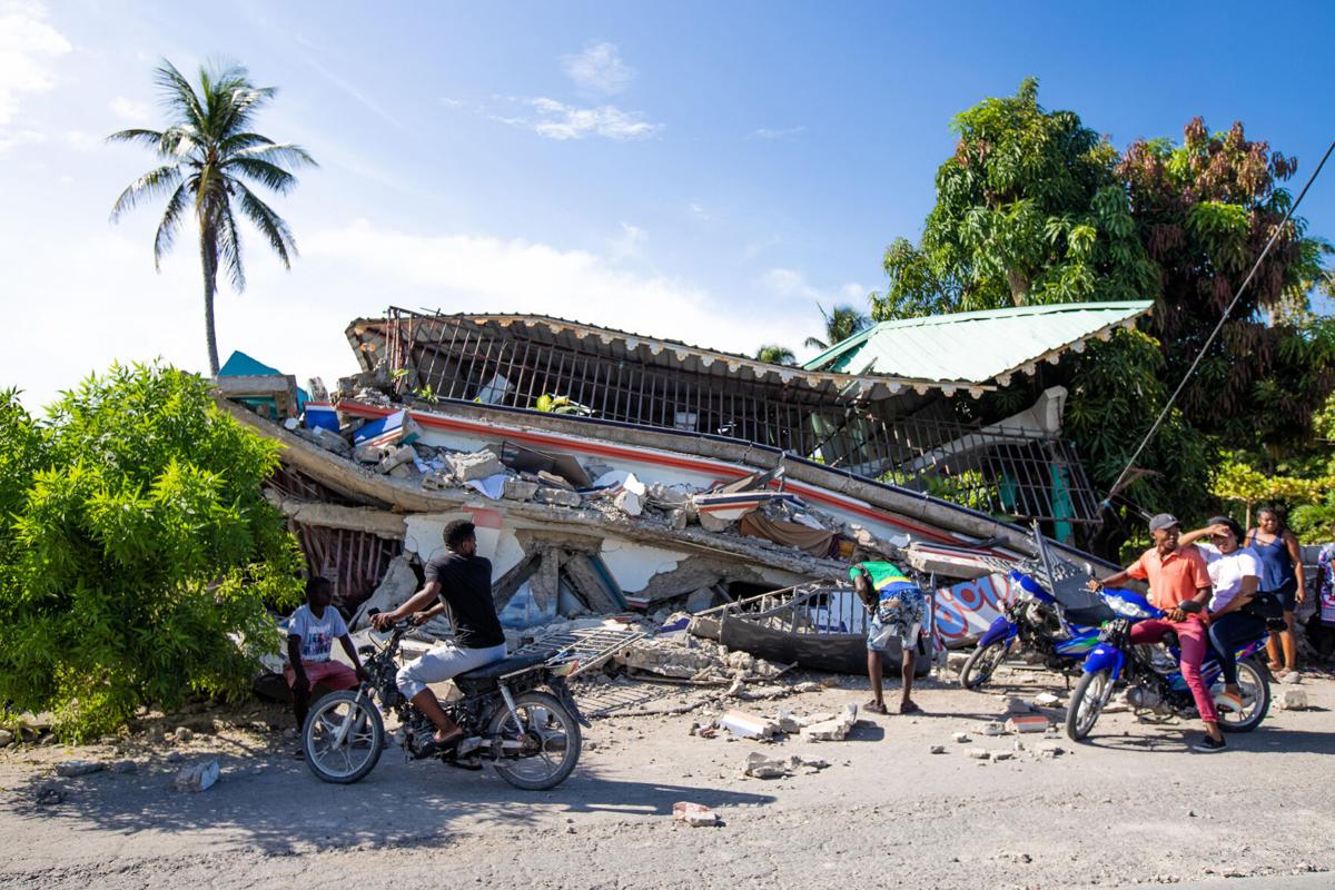Groups of people observe the effects of a 7.2 magnitude earthquake in Los Cayos, Haiti, on Saturday, Aug. 14, 2021.