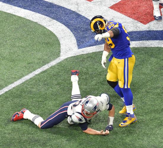 New England Patriots quarterback Tom Brady (12) gets thrown to the ground by Los Angeles Rams defensive end Michael Brockers (90) during Super Bowl LIII on Sunday, Feb. 3, 2019, at Mercedes-Benz Stadium in Atlanta. The Patriots won, 13-3.