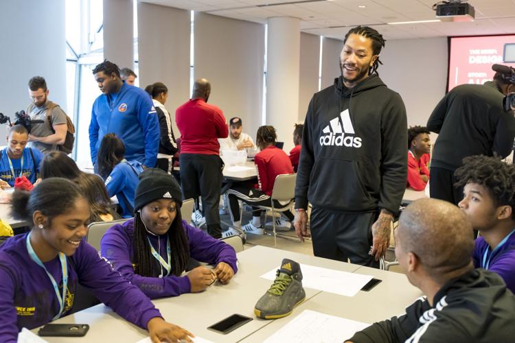 Derrick Rose works with students in a shoe design workshop.
