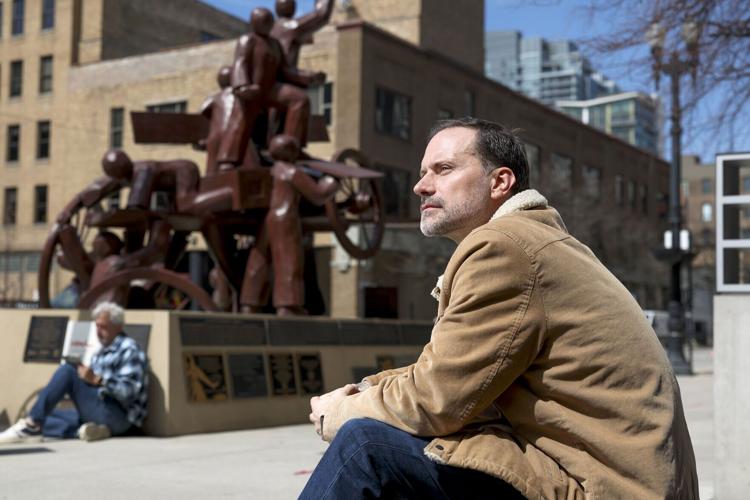 Zayd Ayers Dohrn, a playwright and Northwestern professor, sits near the Haymarket Memorial in the West Loop on April 9, 2026. Dohrn, the son of Bill Ayers and Bernardine Dorhn, the longtime Hyde Parkers and leaders of the militant activist group The Weather Underground, used to take him to the Haymarket Memorial to illustrate the history of activism.