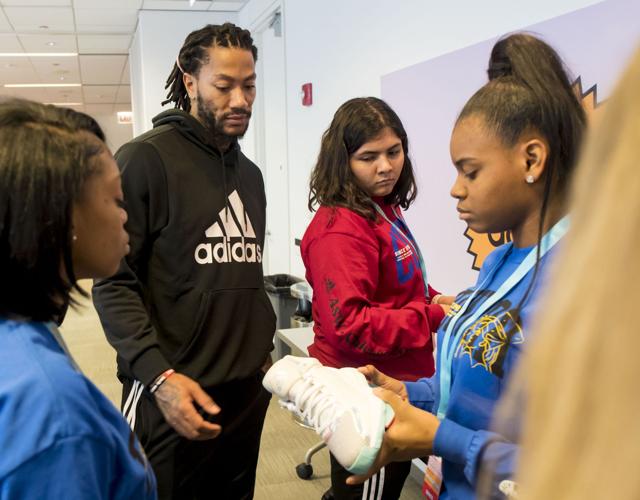 Derrick Rose works with students in a shoe design workshop.