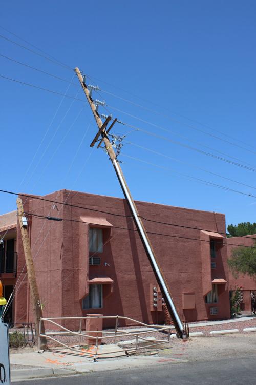 Utility pole blown over onto building