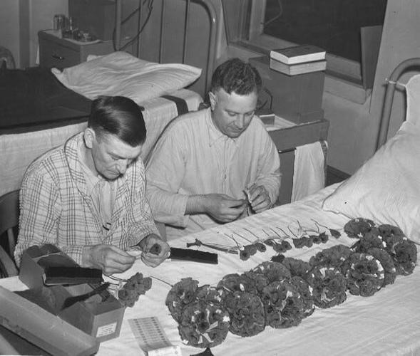Veterans making poppies for Des Moines Poppy day on Saturday May 29, 1937 at the Veterans Administration hospital, Thirtieth Street and Douglas Avenue. The red crepe paper flowers were made at the hospital by veterans who earn one cent on each poppy made. Four American Legion auxiliary units will hold the sale and all proceeds were designated for welfare work.