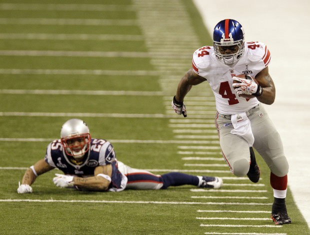 Tight end Aaron Hernandez (81) of the New England Patriots avoids the  tackle of strong safety Deon Grant (34) of the New York Giants to score on  the opening drive of the