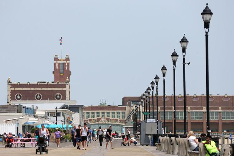 People walk along the boardwalk in Asbury Park, New Jersey, on June 5, 2019.