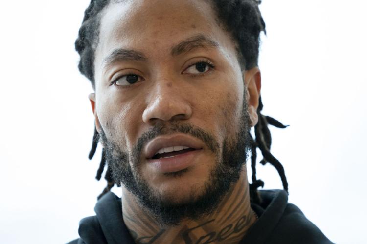 Derrick Rose works with students in a shoe design workshop.