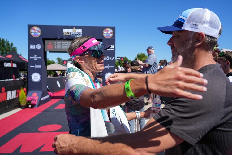 Kristen Yax, left, hugs her husband, Justin Yax, July 19 after winning the women's race during Ironman 70.3 Oregon.