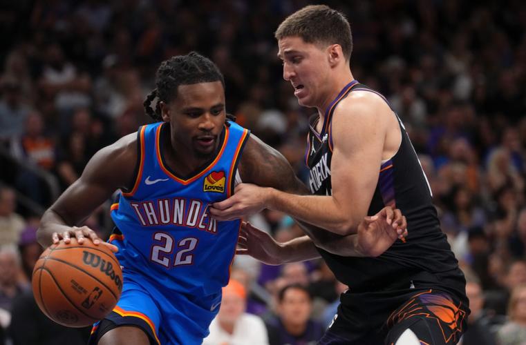 Phoenix Suns guard guard Collin Gillespie (12) defends Oklahoma City Thunder guard Cason Wallace (22) during Game 4 of their playoff series at the Mortgage Matchup Center in Phoenix on April 27, 2026.